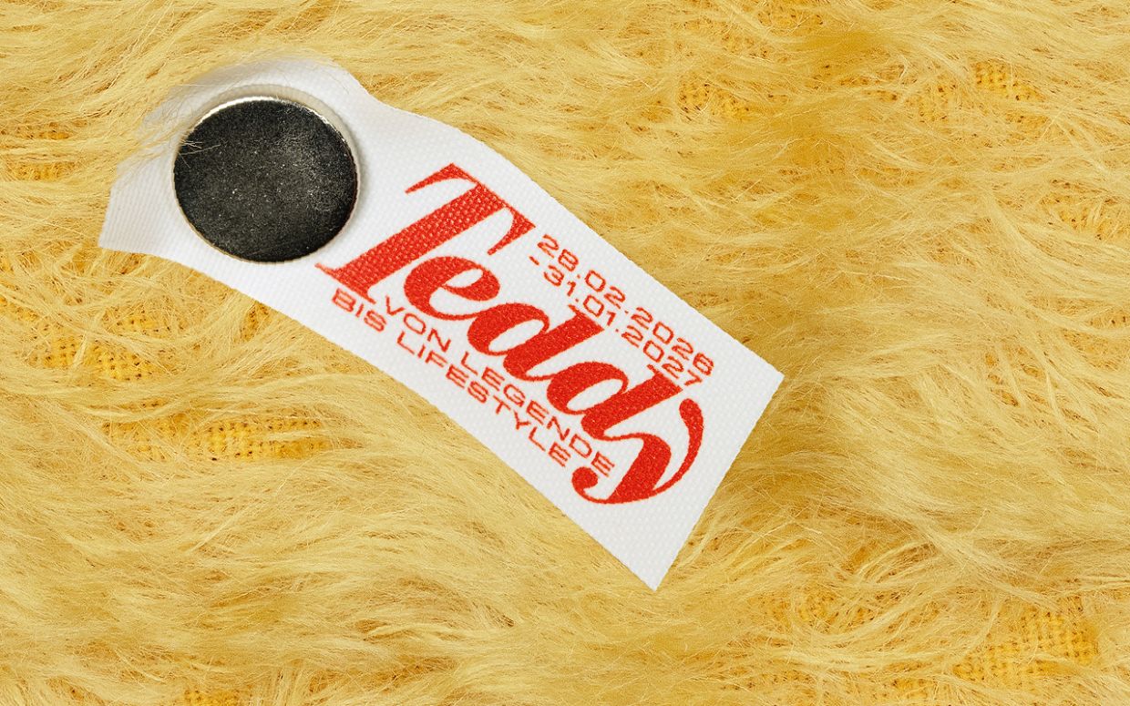 Ein Plakat aus Bärenfell ist geschmückt mit einer Etikette, die den Ausstellungstitel 