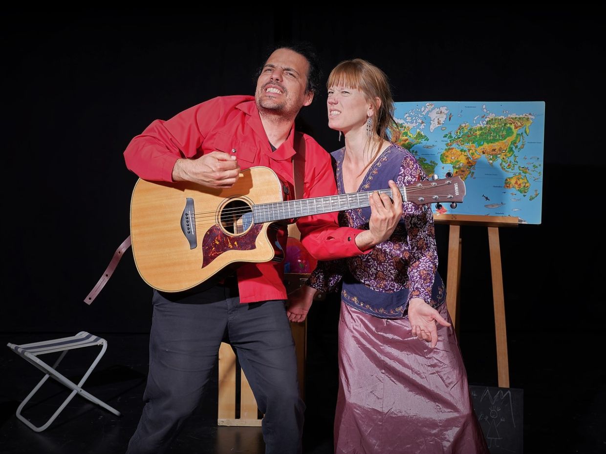 Mann spielt Gitarre und Frau singt