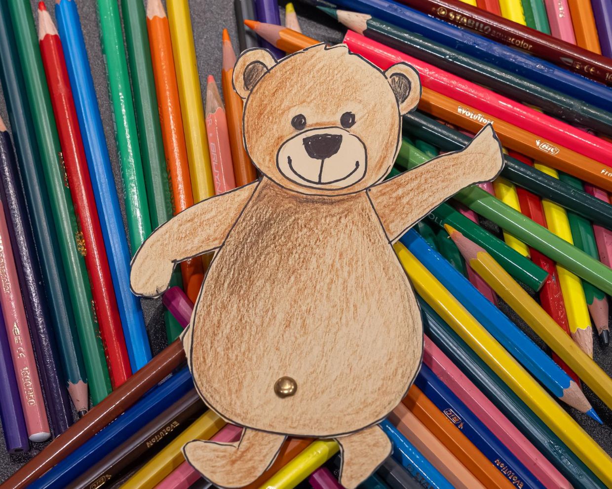 Eine Bärenzeichnung liegt auf ein paar Bleistiften